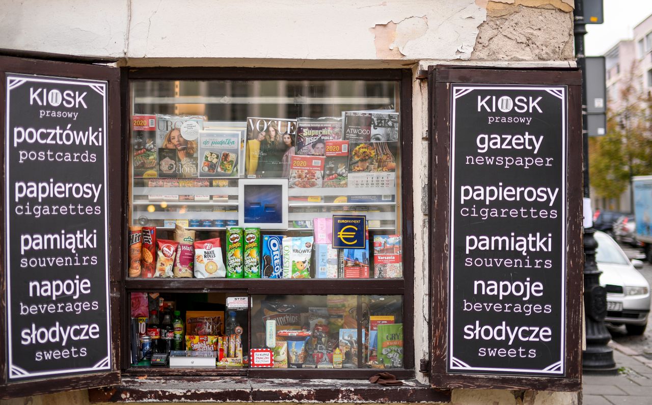 Colorful newsstand in Warsaw featuring magazines, snacks, and beverages.