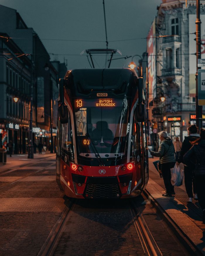 A vibrant street scene featuring a tram in Katowice, Poland at twilight, capturing the urban atmosphere.